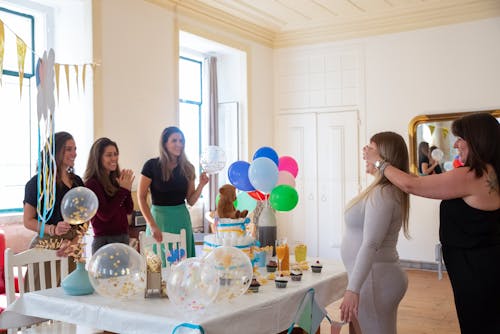 Free Women Standing in Front of Table With Balloons Stock Photo