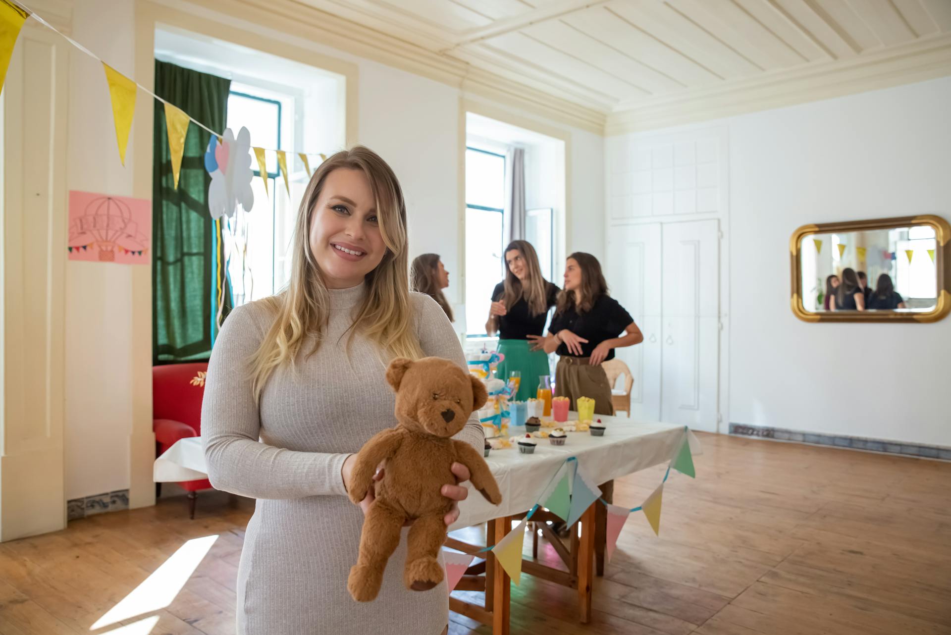 A Woman Holding a Teddy Bear at a Baby Shower