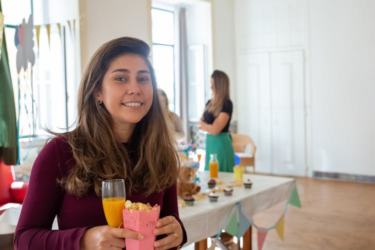 Woman Holding A Glass Of Juice And Popcorn