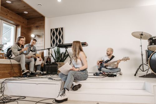 Free A group of young musicians rehearsing with instruments in a modern studio setting. Stock Photo