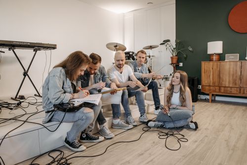 Free A group of young musicians having a rehearsal in a cozy home setting with instruments. Stock Photo