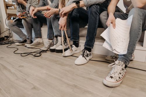 Free Close-up of a group in denim jeans and sneakers, sitting together during casual band practice. Stock Photo