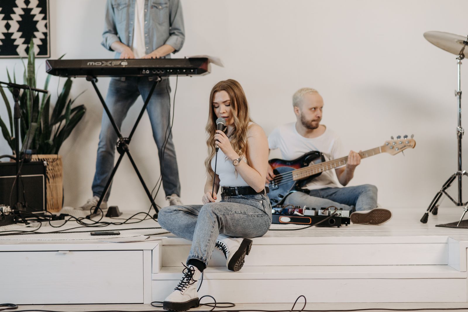 Band members rehearsing together in a bright studio