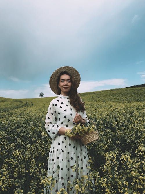 Charming woman with flowers in field