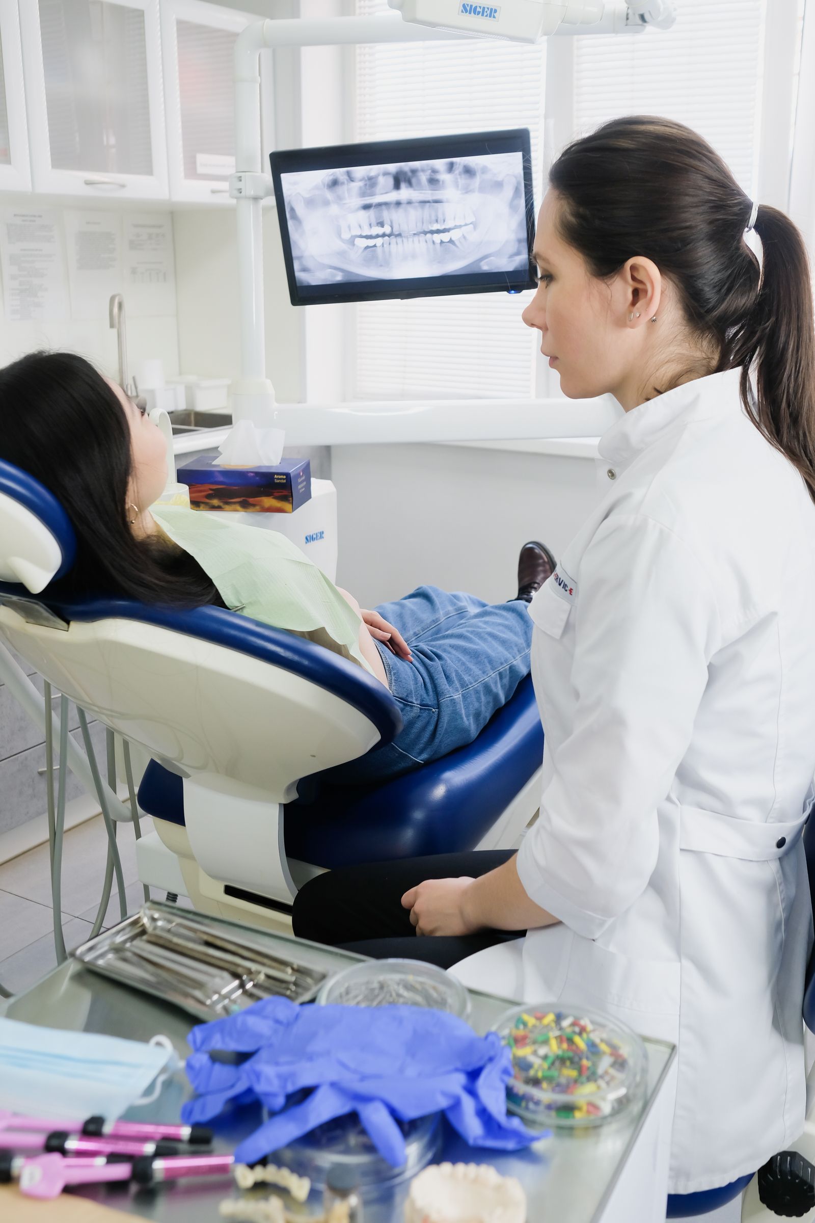 Dentist reviewing a dental X-ray with a patient in a modern clinic