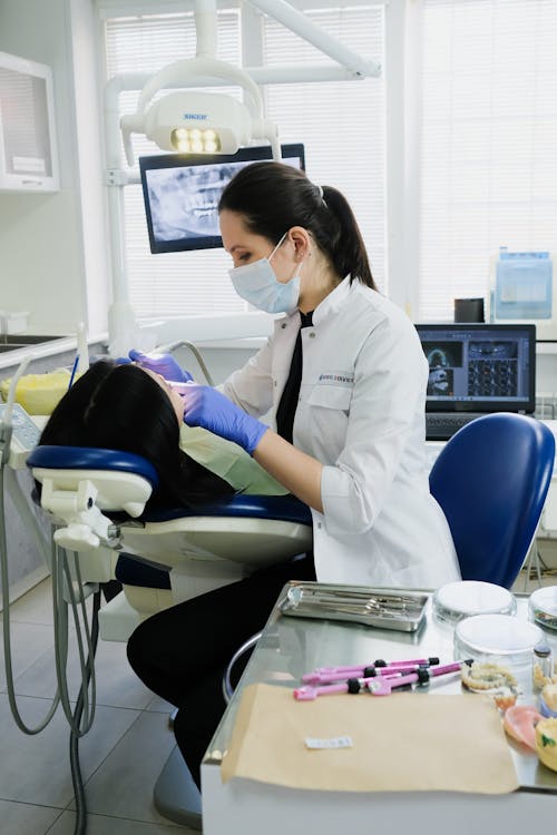 A Woman in White Coat Wearing Blue Face Mask