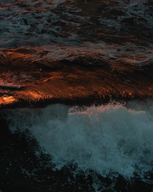 Free Splashing foamy waves of sea at sunset Stock Photo