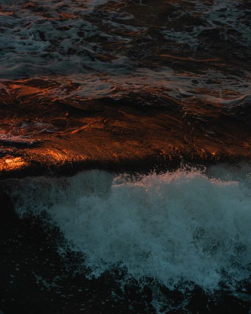 Free From above of powerful foamy waves with splashes of stormy clear sea at sundown Stock Photo