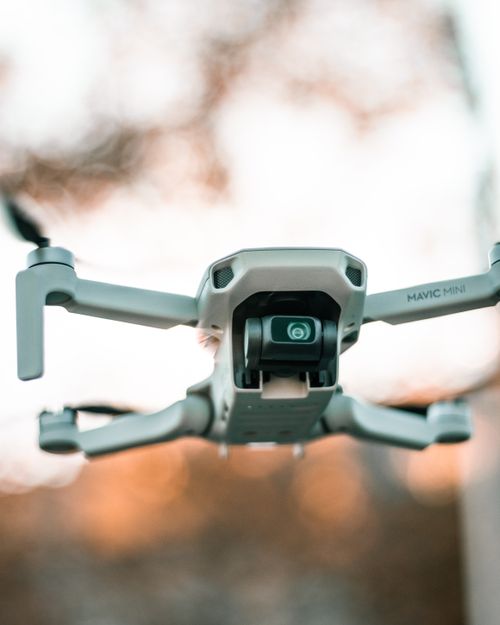 Free Low angle of modern drone with moving propellers and video camera filming environment Stock Photo