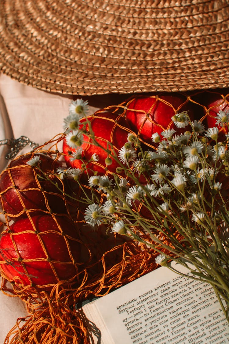 Flowers Near String Bag With Apples