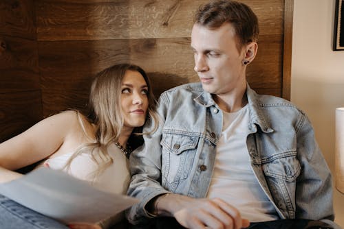 Young Couple Lying in Bed and Looking at Each Other