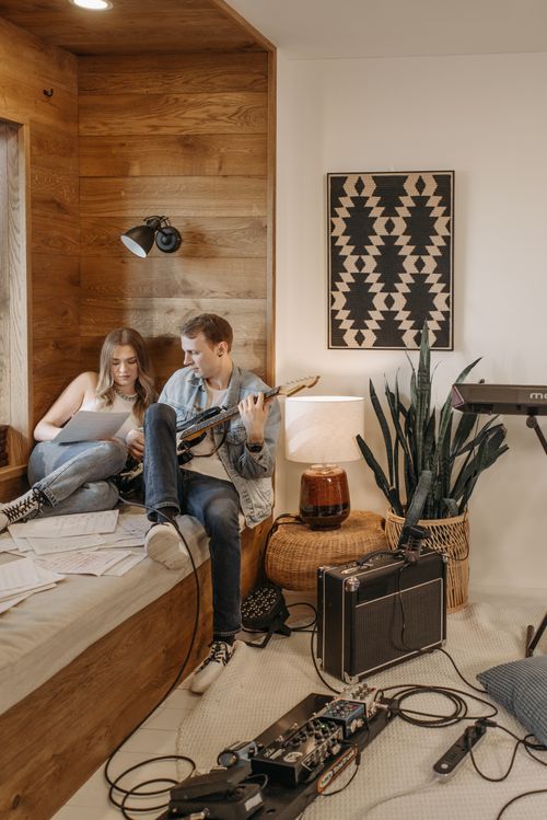 Free Young adults practicing music with guitar and notes in cozy room. Stock Photo