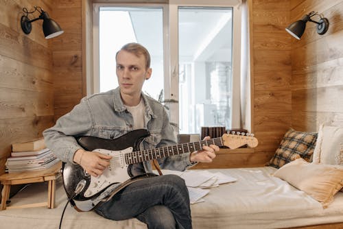 Бесплатное стоковое фото с гитарист, игра, кровать