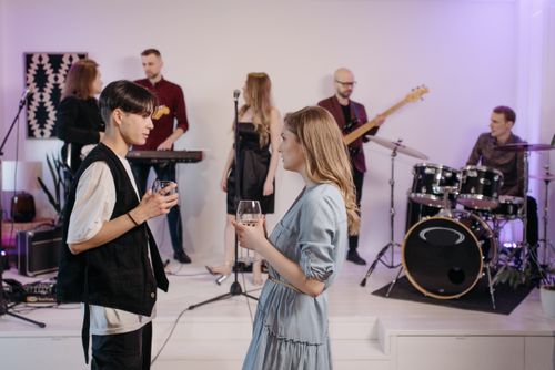 Free Group of friends enjoying a casual indoor home concert, with live music and socializing. Stock Photo