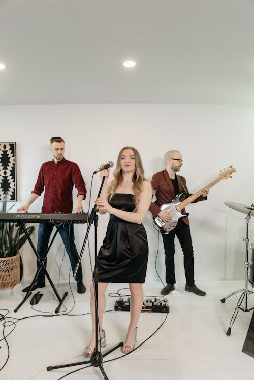 Woman in Black Dress Holding a Microphone