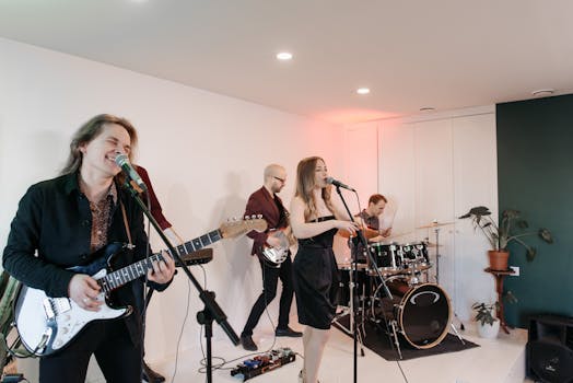 Indie band performing live indoors with electric guitar, drums, and vocals. Energetic and vibrant atmosphere.