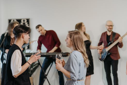 A group of friends enjoying a casual indoor home concert with live music and conversation.