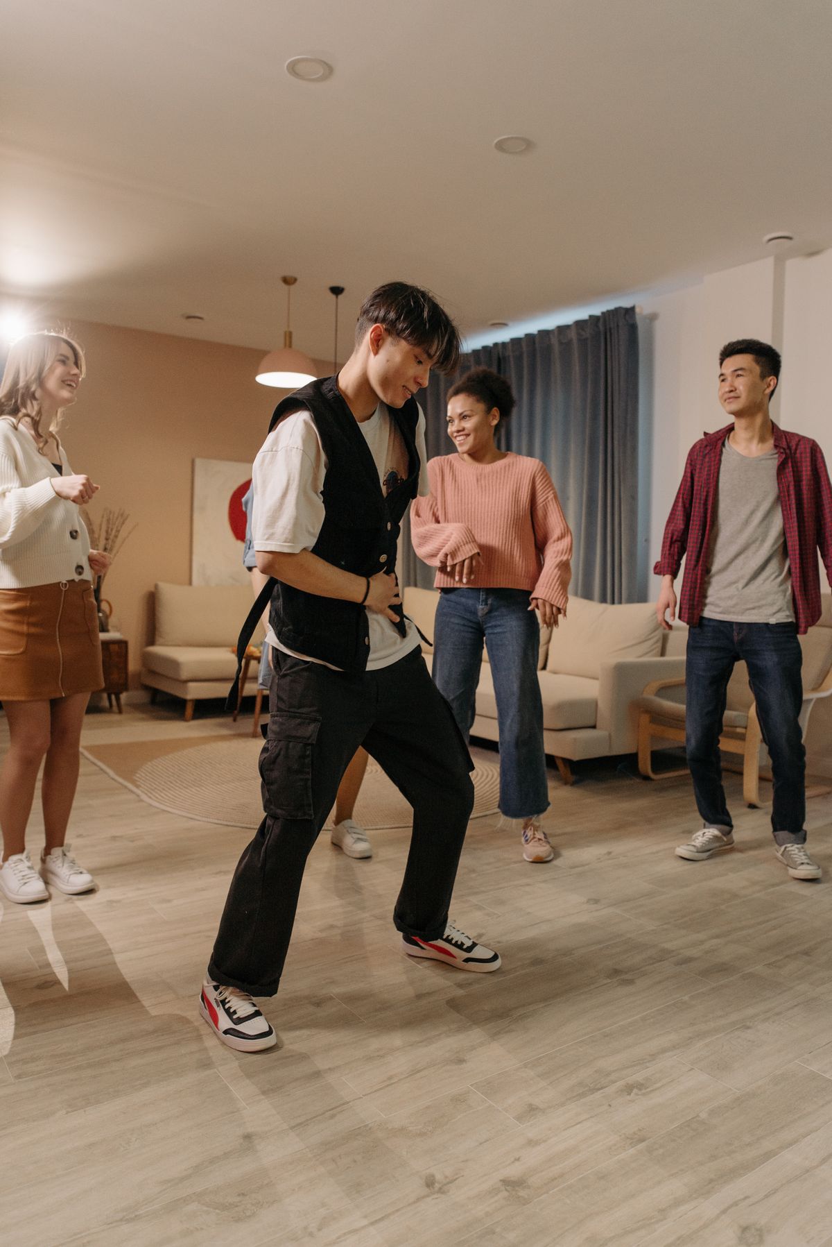 Friends dancing together on a wooden floor in a living room, party games for adults without alcohol