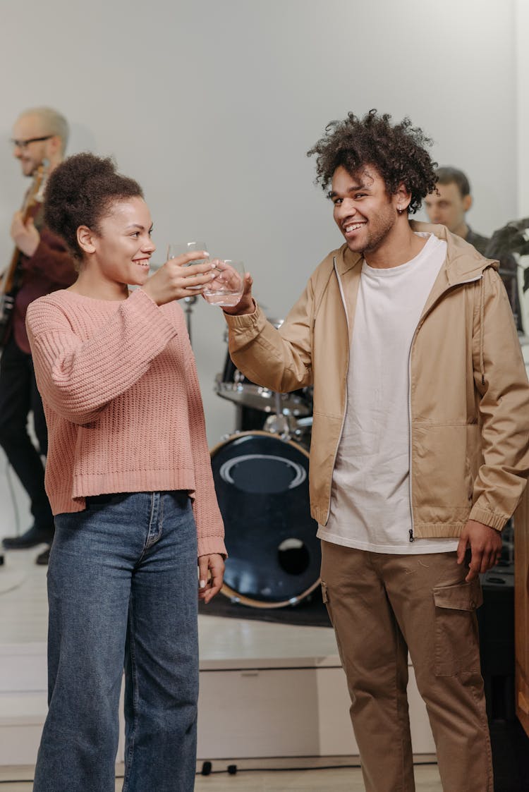 A Smiling Man And Woman Toasting Drinks