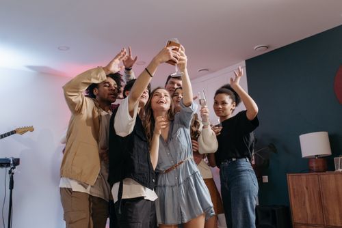 Free Diverse group of adults taking selfie during indoor party, celebrating together. Stock Photo