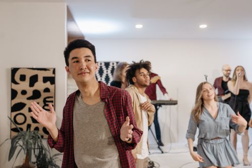 Free A lively group of diverse friends enjoying music and dancing at a modern indoor party. Stock Photo