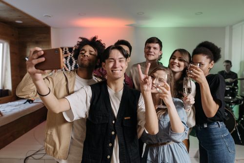 Free A diverse group of friends taking a selfie while enjoying a fun indoor party celebration. Stock Photo