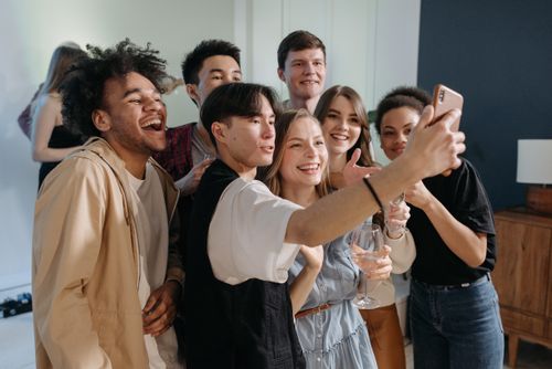 Free A diverse group of friends taking a cheerful selfie together indoors. Stock Photo