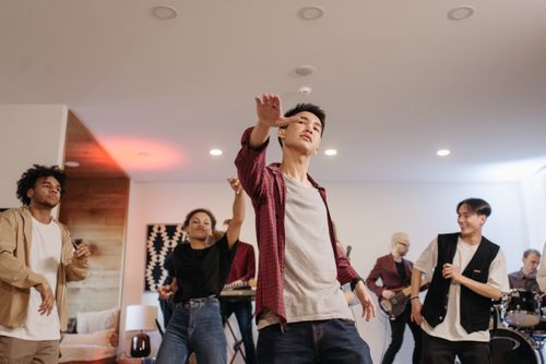 Free Dynamic group of friends enjoying a lively indoor party with live music and dancing. Stock Photo