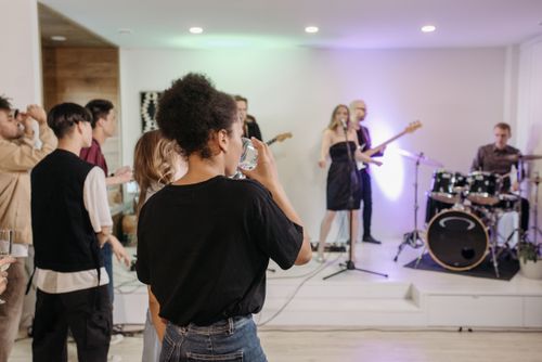 Free A diverse group enjoys a lively home concert with live band and music performances. Stock Photo