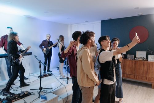 Free Group of friends enjoying a lively house concert with live music and diverse performances. Stock Photo