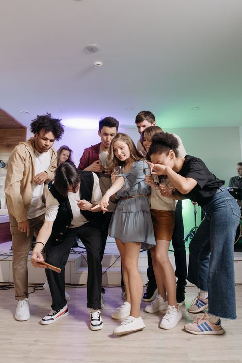 Free Young adults having fun and taking a selfie at a party. Joyful indoor gathering. Stock Photo
