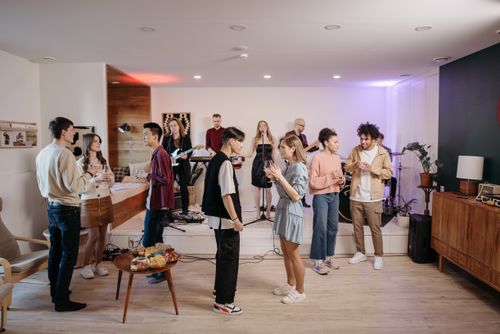 Free A vibrant indoor party atmosphere with friends enjoying live music and conversations. Stock Photo