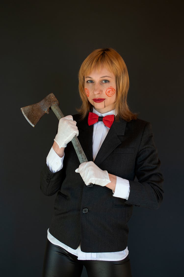 A Woman With Face Paint Holding An Axe