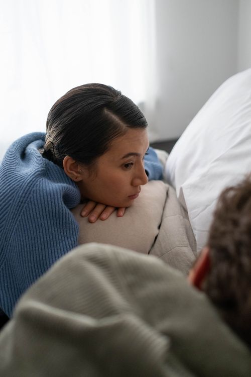 Free Woman in blue sweater resting indoors, conveying a peaceful, contemplative mood. Stock Photo