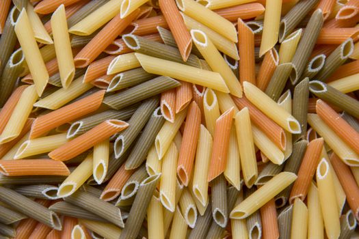 Vibrant close-up of uncooked tri-color penne pasta.
