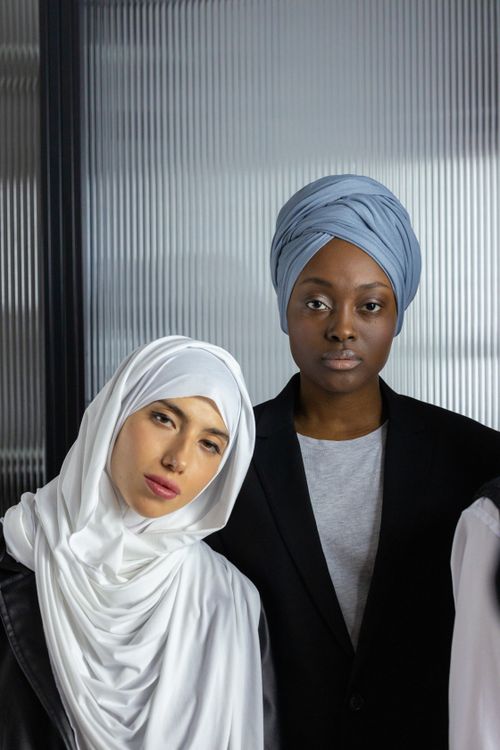 Free Portrait of diverse women wearing hijab and turban indoors, emphasizing multicultural beauty. Stock Photo