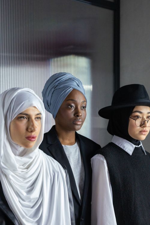 Free A diverse group of women wearing hijab, turban, and stylish hat indoors, showcasing cultural variety. Stock Photo