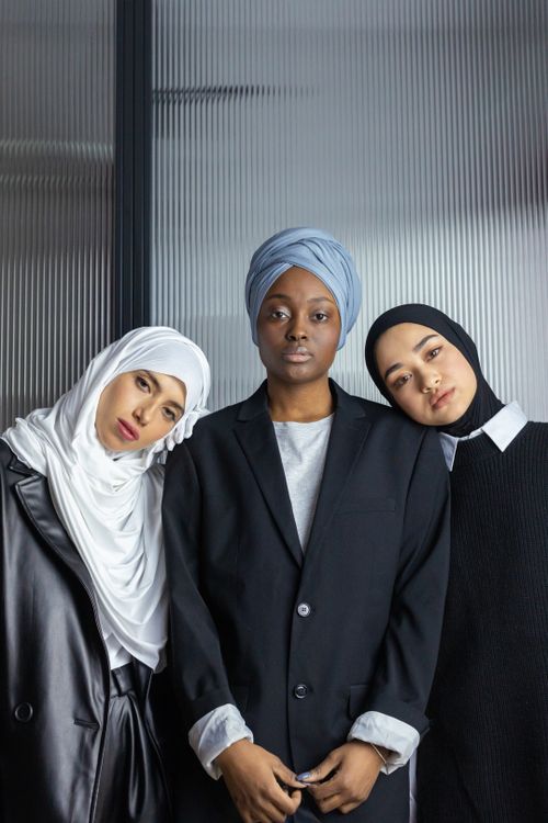 Free Three diverse women wearing hijabs, symbolizing strength and unity, indoors. Stock Photo