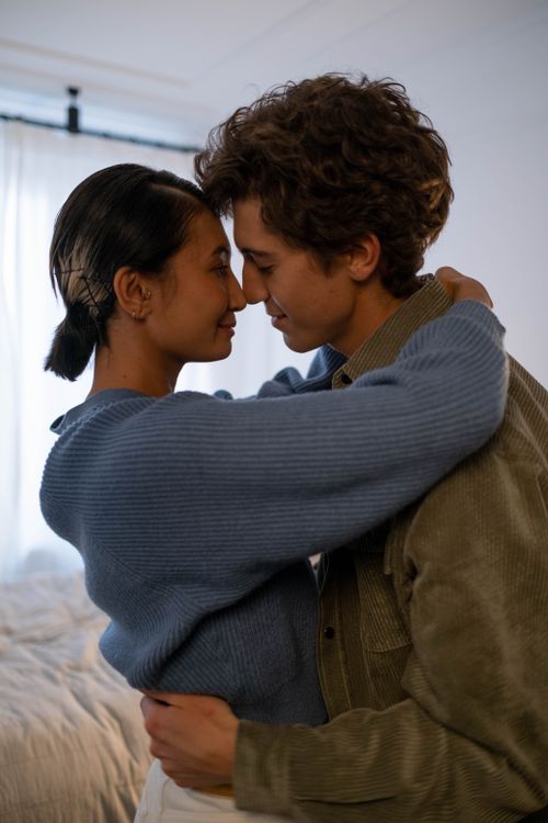 Free A young couple sharing a tender moment in an intimate indoor setting. Stock Photo
