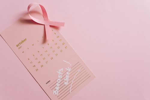 Free Pink October calendar with ribbon symbolizing breast cancer awareness, emphasizing early detection. Stock Photo