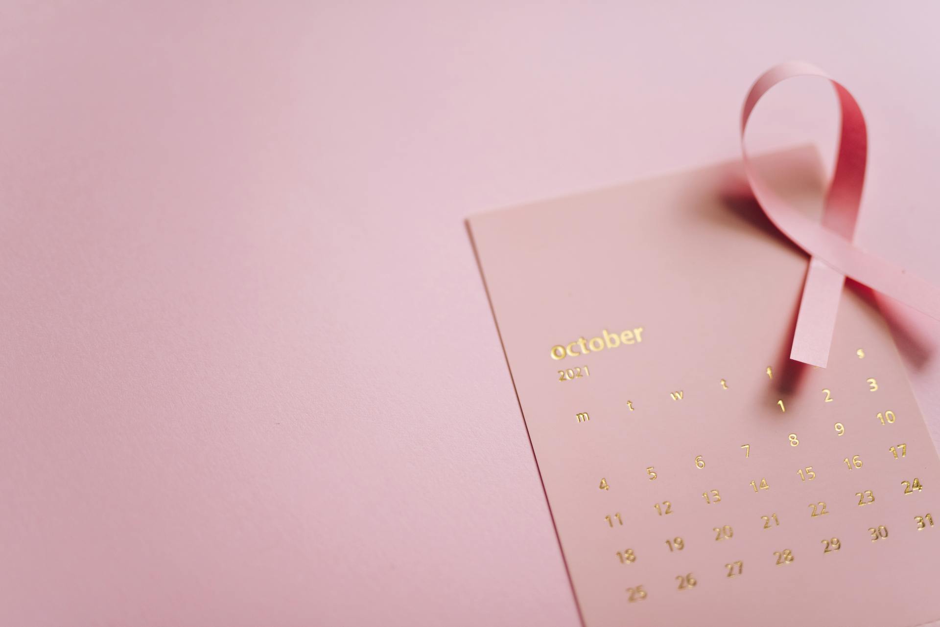 Close-Up Shot of a Pink Ribbon on a Calendar