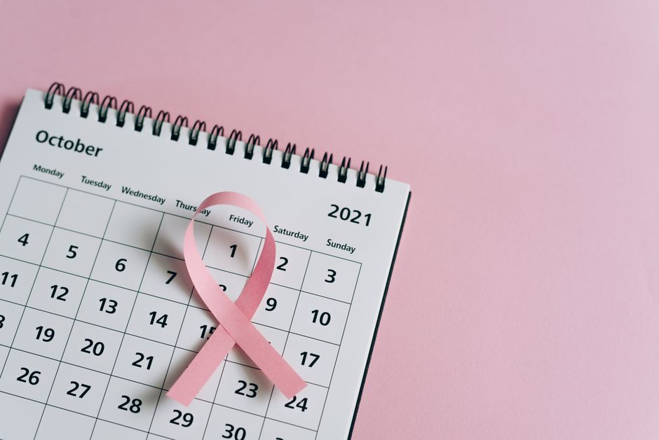 Close-up of a pink ribbon on an October 2021 calendar, symbolizing breast cancer awareness.