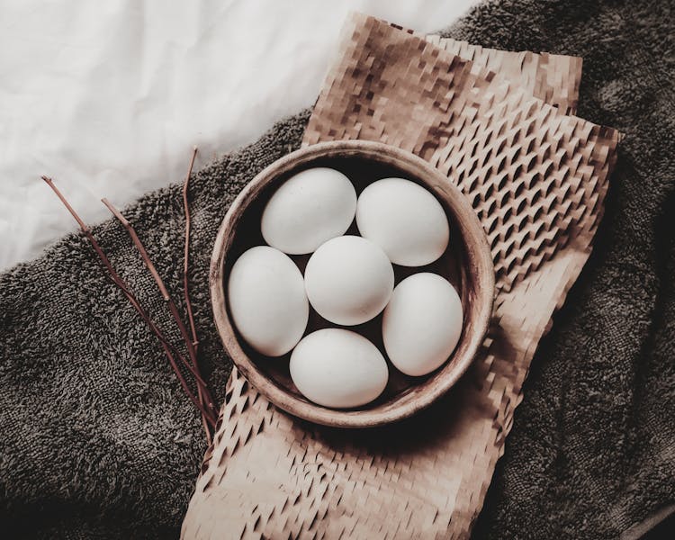 Raw Eggs In Wicker Bowl Placed Above Paper