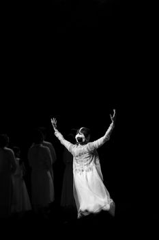 Captivating black and white photo of a dancer raising arms during a live performance.