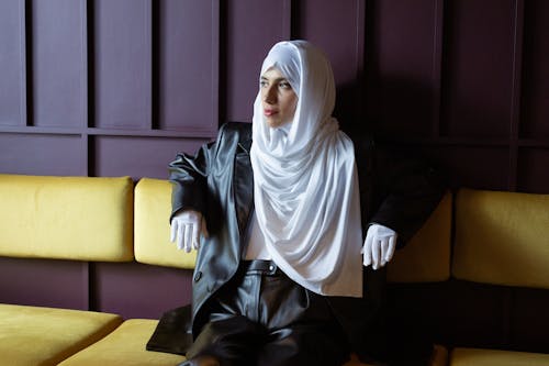 Woman in White Hijab Sitting on Yellow Couch
