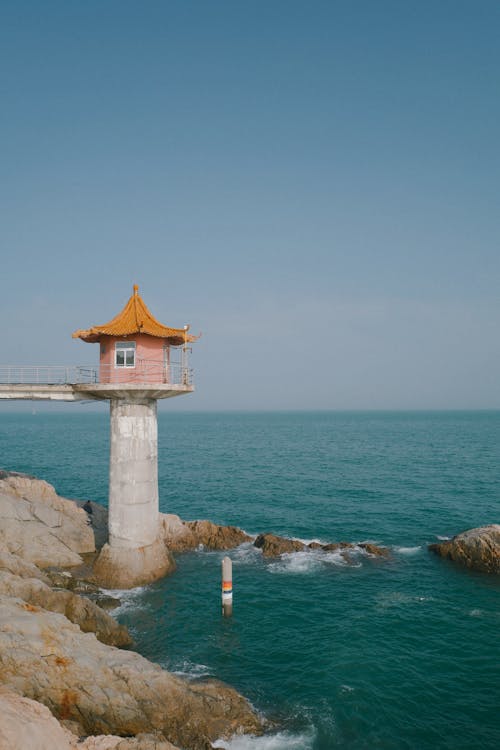 Free A Lighthouse on the Body of Water Stock Photo