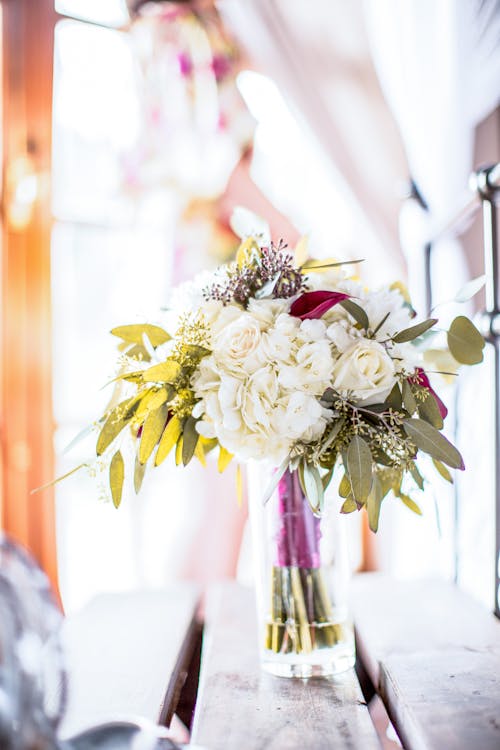 Free Fresh bouquet of aromatic flowers placed in transparent glass vase against blurred background in light room Stock Photo