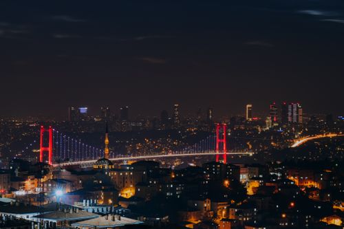 Free Illuminated Istanbul cityscape featuring a suspension bridge and skyline at night. Stock Photo