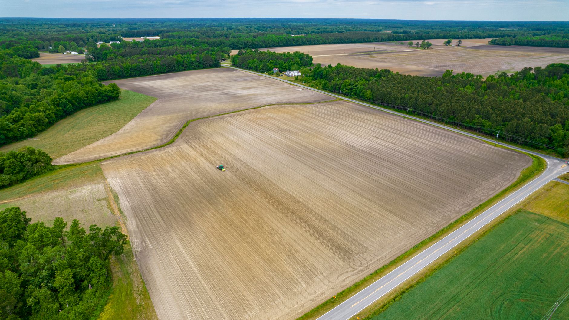 Scenic aerial view of vast farmland in North Carolina, highlighting agricultural fields and rural landscape.