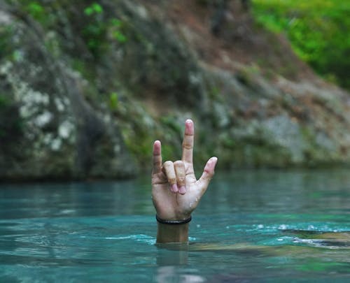 Person Doing a Hand Gesture While Underwater
